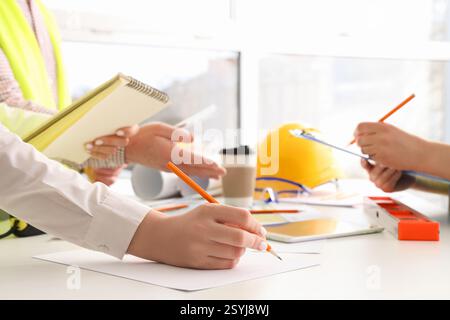 Team of constructors working at table in room, closeup Stock Photo