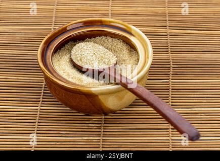 One spoon of brown sugar placed on a ceramic cup closeup view, natural and organic ingredients for cooking. Stock Photo