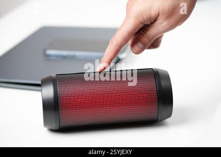 Close-up of a male hand connecting a portable speaker at office or home Stock Photo