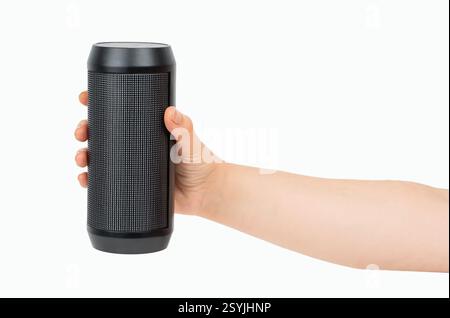Portable wireless speaker in hand isolated on white background. Black mobile wireless bluetooth speaker with ribbed texture in female hand. Case made Stock Photo