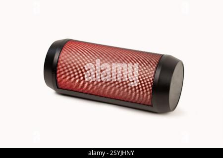 Red portable wireless speaker isolated on white background. Mobile loudspeaker red color with ribbed texture and push control buttons.Horinzontal posi Stock Photo