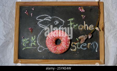 A chalkboard with a drawn bunny and a donut. Happy easter. Stock Photo