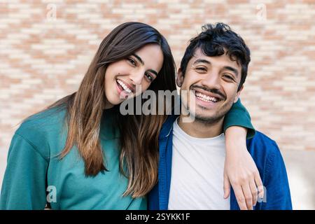 Young multiracial couple smiling at camera standing together outdoor Stock Photo