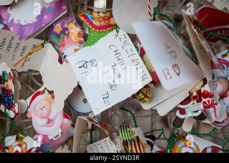Malaga, Spain 27 December 2024 notes with christmas and new year wishes (like 'cherish the moment') left on a christmas tree Stock Photo