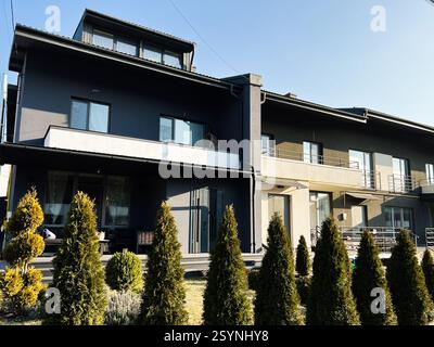 Klenovi Hai, Ukraine - February 27, 2025: Contemporary apartment complex with vibrant aesthetics, featuring manicured hedges and modern balconies Stock Photo