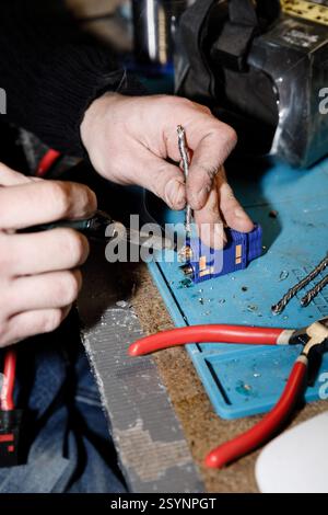 Donetsk Region, Ukraine. 18th Jan, 2025. An engineer works on drone components in a workshop of the 93rd Mechanized Brigade. The hands are focused on intricate repairs and soldering tasks. Engineers of the 93rd Mechanized Brigade are seen working in a drone workshop assembling and repairing critical electronic components. As modern warfare evolves, drones play an increasingly vital role enhancing reconnaissance, strike capabilities and battlefield efficiency. Their expertise directly contributes to Ukraine's defense efforts. Credit: SOPA Images Limited/Alamy Live News Stock Photo