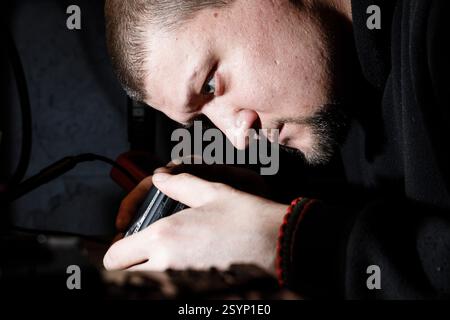 Donetsk Region, Ukraine. 18th Jan, 2025. An engineer focuses intently on assembling drone components in the workshop of the 93rd Mechanized Brigade. Engineers of the 93rd Mechanized Brigade are seen working in a drone workshop assembling and repairing critical electronic components. As modern warfare evolves, drones play an increasingly vital role enhancing reconnaissance, strike capabilities and battlefield efficiency. Their expertise directly contributes to Ukraine's defense efforts. (Credit Image: © Mykhaylo Palinchak/SOPA Images via ZUMA Press Wire) EDITORIAL USAGE ONLY! Not for Commer Stock Photo