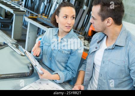 male and female factory workers in discussion Stock Photo