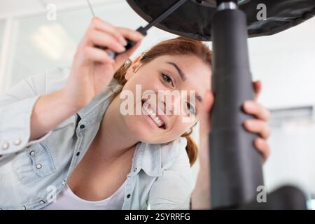 happy woman is screwing a chair Stock Photo - Alamy