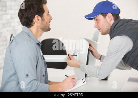 2 concentrated men in fixing a chair Stock Photo