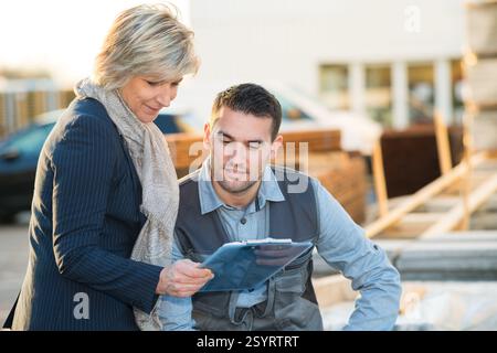 warehouse workers with clipboard discussing something Stock Photo