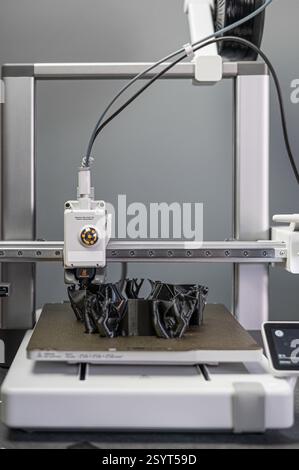 3D printer prints an object. The process of printing model on 3D printer. Model printed on 3D printer from molten plastic. 3D printing technologies Stock Photo