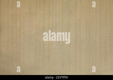Texture and background of yellowed shade. The building wall, painted with beige water-based paint. Old surface in faded beige color with stains Stock Photo