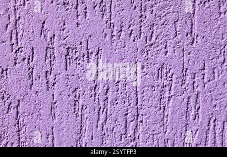 Purple textured wall, background. Plastered building wall, painted with violet water-based paint. Decorated surface with embossed pattern and strokes Stock Photo