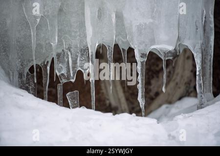 A detailed close-up of icicles hanging from a frozen surface, showcasing intricate ice formations and the beauty of winter nature. Stock Photo