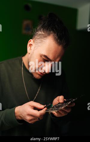 Vertical portrait of computer technician carefully cleaning motherboard components with small brush, focusing on precision and hardware maintenance Stock Photo