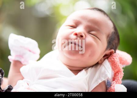 Newborn baby smiling in mother's hands, selective focus in her eyes, Family concept Stock Photo