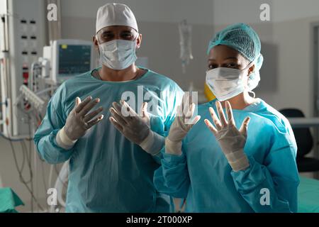 Portrait of diverse surgeons wearing surgical gowns in operating theatre at hospital Stock Photo
