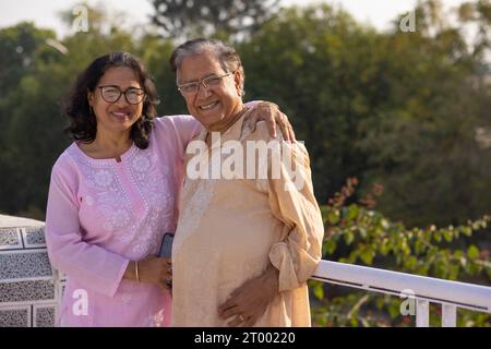 Portrait of happy Mature couple standing together on rooftop Stock Photo