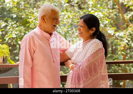 Portrait of happy senior couple standing together in balcony Stock Photo