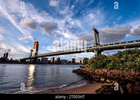 The Manhattan Bridge seen from the Pebble Beach in Brooklyn Bridge Park - New York City Stock Photo