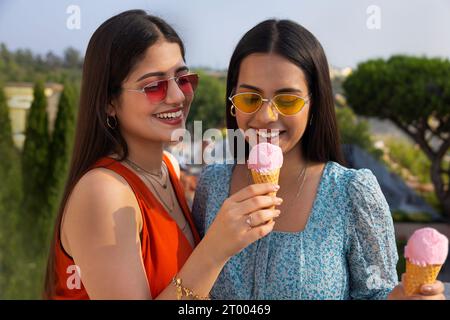 Portrait of young women eating ice cream in cone Stock Photo