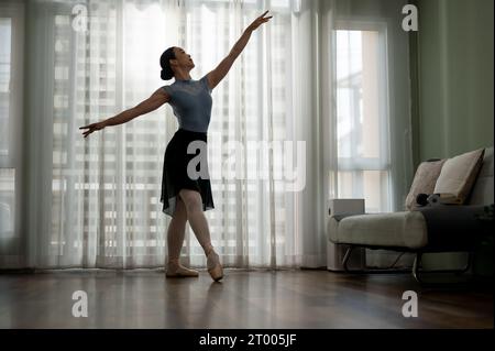 Young ballerina dancing and practicing her movement at home before the show. Tiptoe movements. Concept of classic ballet Stock Photo
