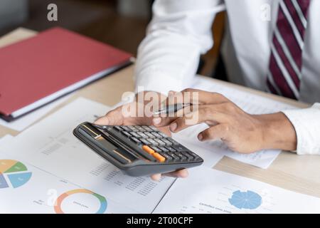 Businessman Accountant analyzing investment charts Invoice and pressing calculator buttons over documents. Accounting Bookkeeper Stock Photo