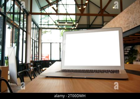 Laptop with Mock up blank screen on wooden table in front of cafe space for text. product display computer laptop montage- techn Stock Photo