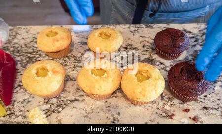 Filling Vanilla, Chocolate Cupcakes with Lemon, Raspberry Stock Photo
