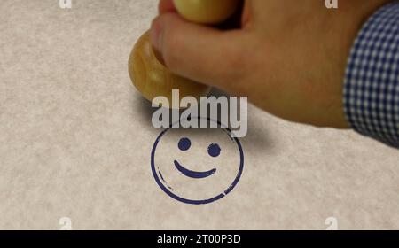 Smiley emoticon stamp and stamping hand. Smile emoji concept. Stock Photo