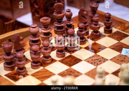 Chess set made of wood with brown and white pieces and a shiny playing surface Stock Photo