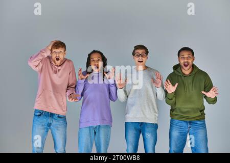 four surprised multicultural friends in urban outfits looking at camera, cultural diversity Stock Photo