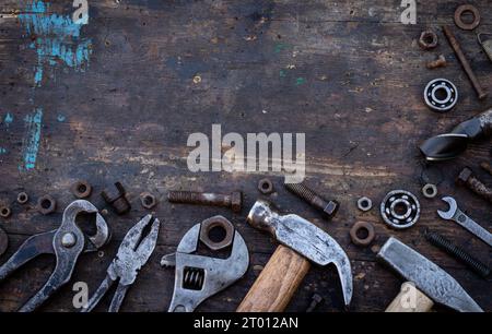 Old work tools nuts, bolts and bearings lie on a wooden workbench Stock Photo
