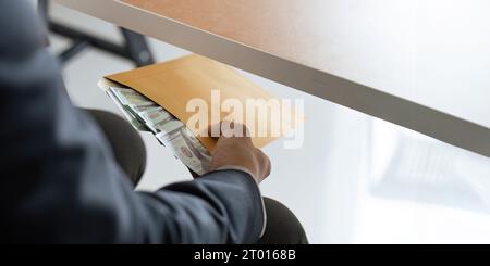 Businessman briefcase document envelope with dollar banknotes while money passes under a table. business accept illegal secret agreement money Stock Photo