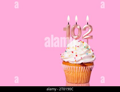 Birthday Cake With Candle Number 102 - On Pink Background. Stock Photo