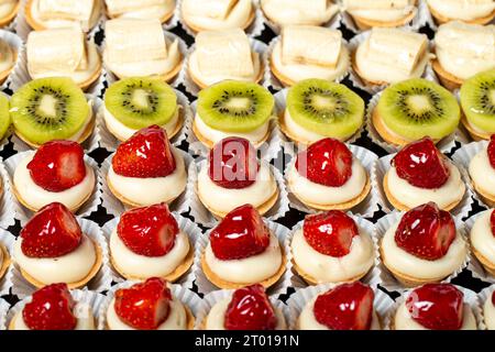 Fruit tartlet. Banana, kiwi and strawberry tartlets on a white background. Top view Stock Photo