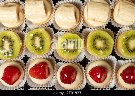 Fruit tartlet. Banana, kiwi and strawberry tartlets on a white background. Top view Stock Photo