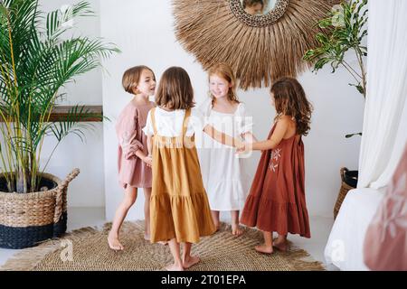 Four children girls had a party, joyfully twirling holding hands Stock Photo