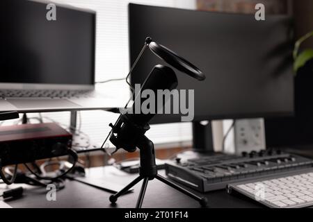 Podcasting set up with computers, keyboard and microphone on desk at home Stock Photo