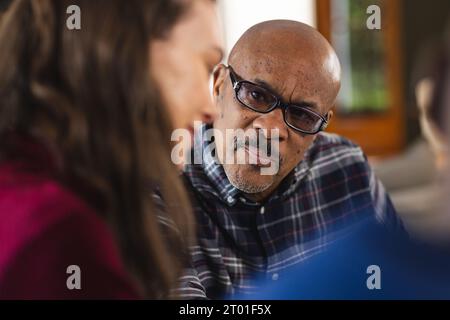 Diverse couple and biracial male financial advisor talking at home Stock Photo