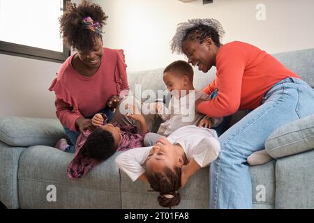 Happy african family playing on sofa, enjoy and having fun together. Horizontal extended family. Stock Photo