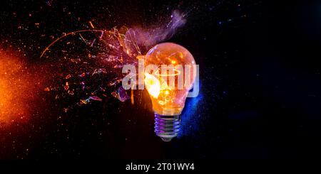 bulb breaks and creates many fragments on a black background Stock Photo