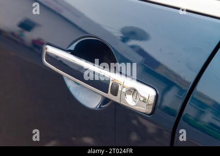 chrome car door handle with rubber keyless entry button to open the vehicle without looking for the key in the pockets wasting no time Stock Photo