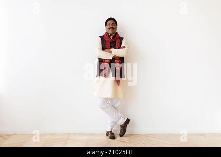 Happy mature indian man in national clothes posing on white Stock Photo