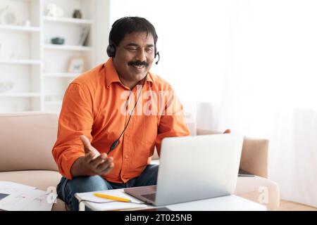 Middle aged indian man working at customer service remotely Stock Photo