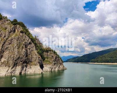 Scenic view of the reservoir of the Vidraru dam in Romania. A high rocky mountain on the artificially created Lake Vidraru. Copy space. Selective focu Stock Photo