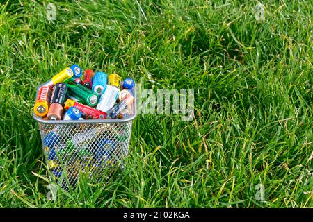 Nizhniy Novgorod, Russia, September 2023. Used alkaline batteries on green grass. Environmental pollution problem concept. Toxic waste and recycling Stock Photo