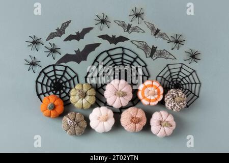 Happy Halloween holiday concept. Halloween decorations, spiders, bats, knitted webs, pumpkins on green background. Flat lay, top view Stock Photo