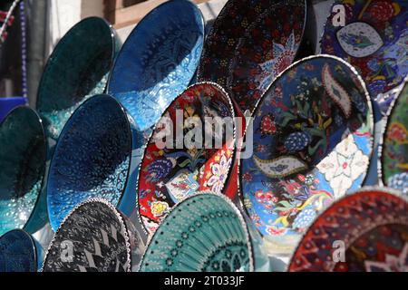 Rows of beautiful multicoloured decorative Bowls of various designs of repetitive and Floral patterns, displayed on White Shelves, seen from the side Stock Photo